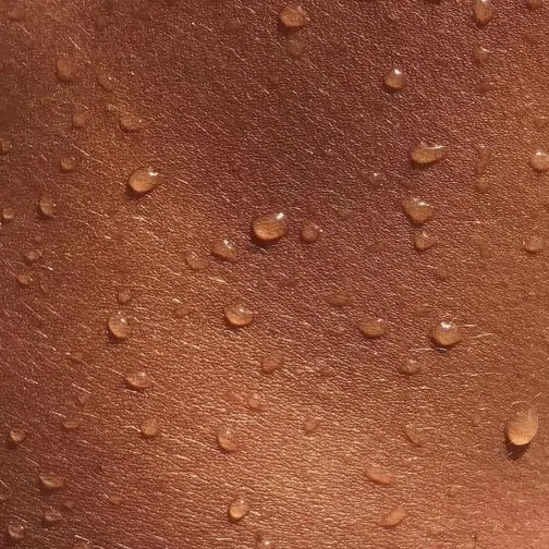 Skin with water droplets in the summer sun